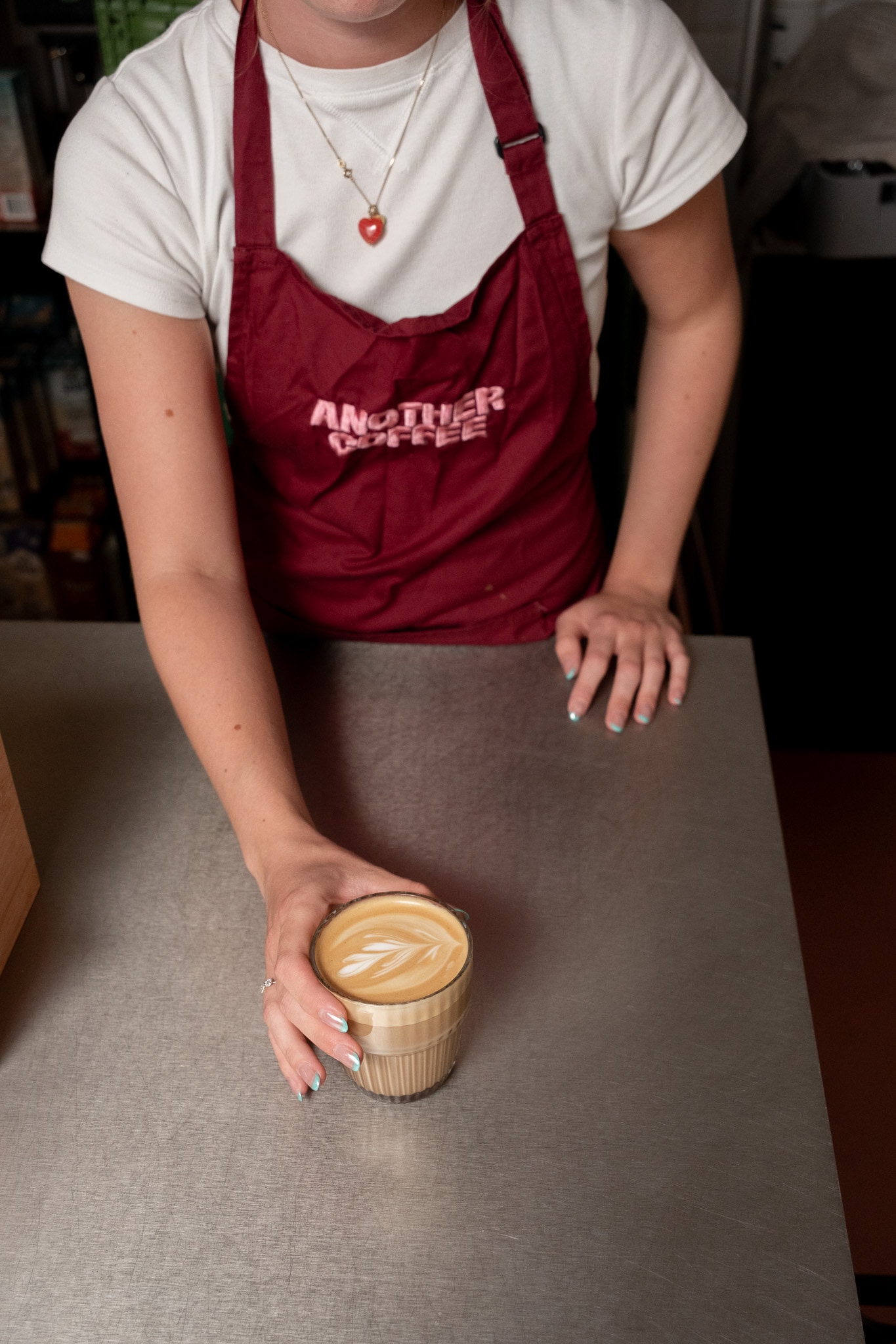 En kaffe rækkes over disken hos Another Coffee